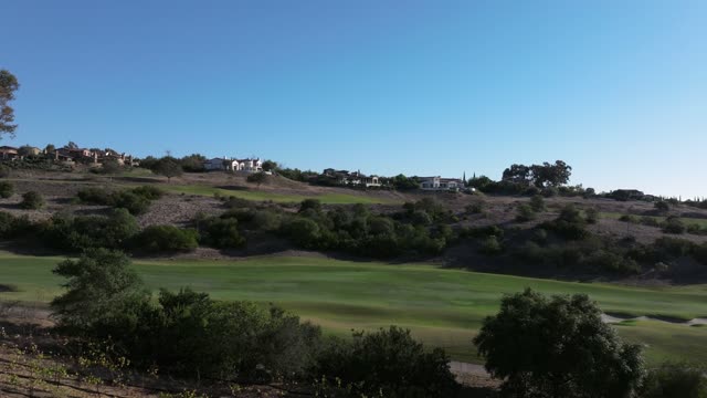 Low aerial view of a residential street, homes and open country in Santaluz.