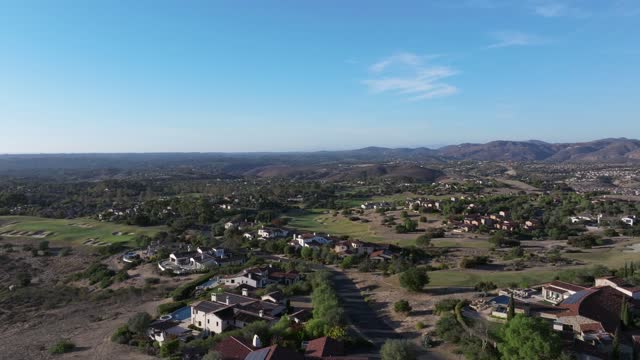 Aerial view of a residential street, homes and open country in Santaluz.