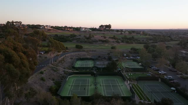 Aerial view of the country inland, homes and traffic in Santaluz, with swimmers in the water.