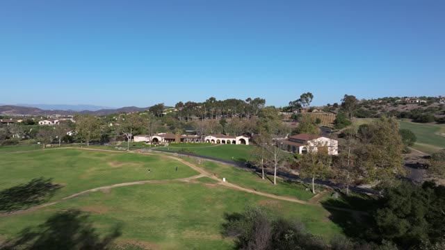 Low aerial view of the country inland, homes and the buildings in Santaluz, with people walking.