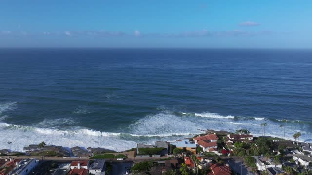 Aerial view of a residential street, the surf and palm trees at Beach Barber Tract.