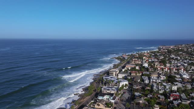 Aerial view of a residential street, the surf and the ocean at Beach Barber Tract.