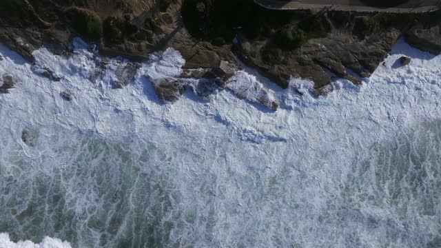 Aerial view of the cliffs, the surf and the ocean at Beach Barber Tract.