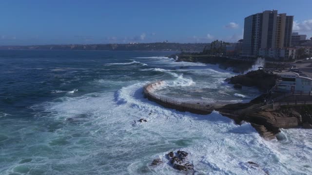 Aerial view of the cliffs, the surf and the ocean at La Jolla Village.