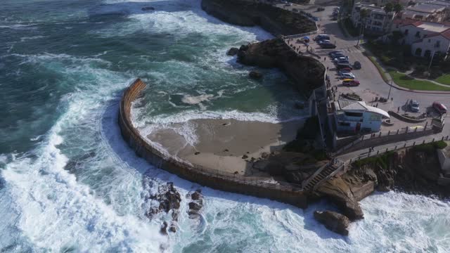 Aerial view of the cliffs, the surf and the ocean at La Jolla Village.