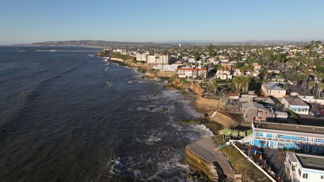 Aerial view of the cliffs, the surf and palm trees at Sunset Cliffs.