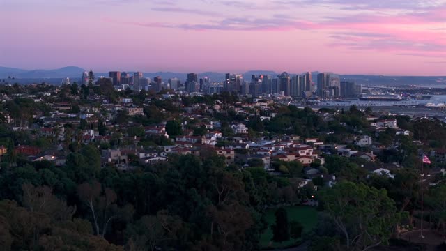 A view of the Downtown San Diego Skyline over Mission Hills during sunset and twilight | Drone Video – 1