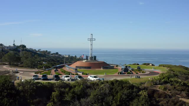 Low aerial view of the cliffs, the ocean and traffic at Mount Soledad.