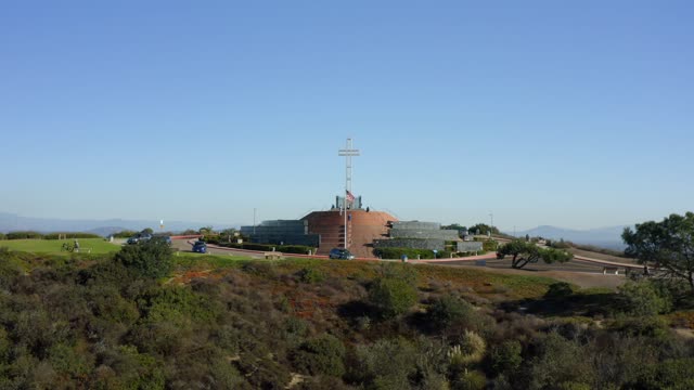 Low aerial view of a park, traffic and open country at Mount Soledad.