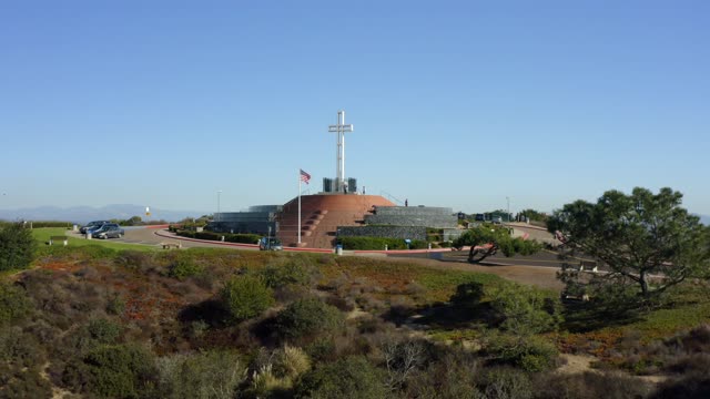Low aerial view of a park, traffic and open country at Mount Soledad.