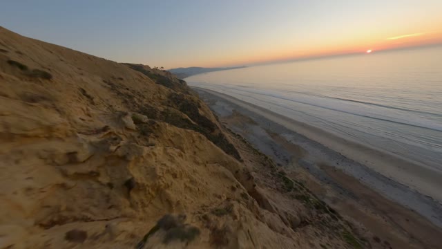 Low aerial view of the cliffs, the ocean and the beach at Black’s Beach.