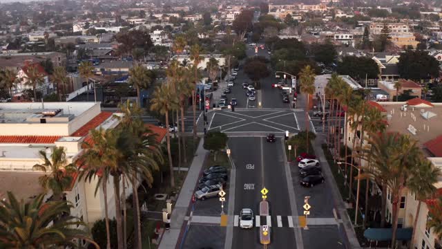 Aerial view of the downtown streets, palm trees and homes in Carlsbad, with people walking.