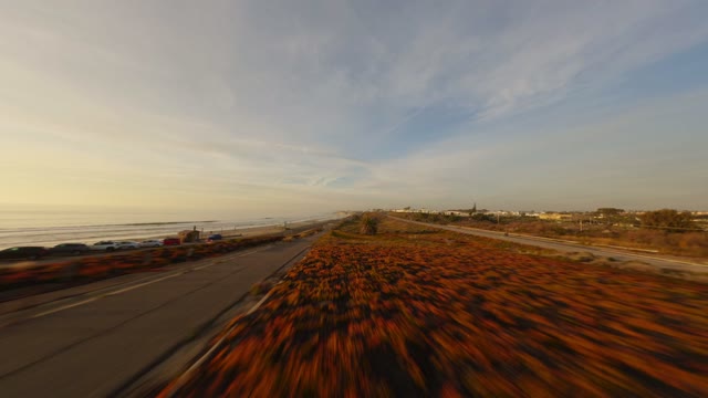 Low aerial view of the beach, the ocean and traffic in Carlsbad.