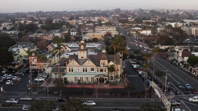 Aerial view of the downtown streets, palm trees and homes in Carlsbad, with people walking.