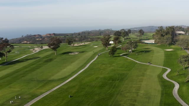 Low aerial view of the country inland, traffic and open country at Torrey Pines, with people walking.