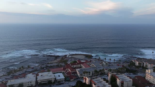 Aerial view of the cliffs, the surf and palm trees at La Jolla Cove.