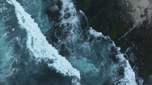 Aerial view of the cliffs, the surf and the ocean at La Jolla Cove.