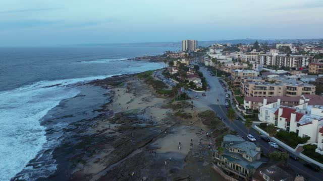 Aerial view of the beach, the surf and the ocean at La Jolla Cove, with people walking.
