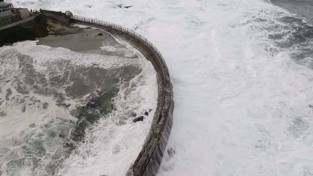 Aerial view of the cliffs, the surf and the ocean at La Jolla Cove.