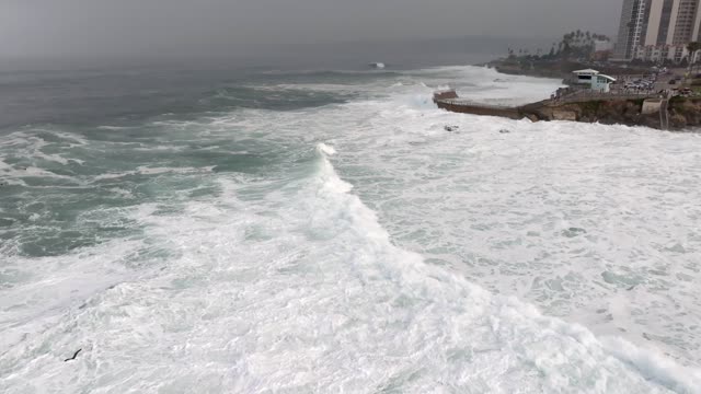 Aerial view of the cliffs, the surf and the ocean at La Jolla Cove.