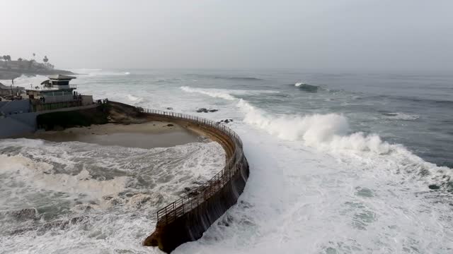 Aerial view of the cliffs, the surf and the ocean at La Jolla Cove.