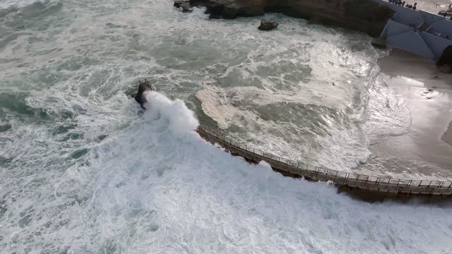 Aerial view of the cliffs, the surf and the ocean at La Jolla Cove.