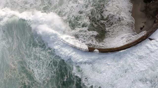 Aerial view of the cliffs, the surf and the ocean at La Jolla Cove.