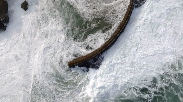 Aerial view of the cliffs, the surf and the ocean at La Jolla Cove.