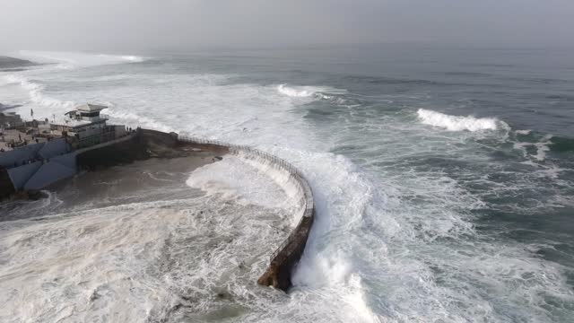 Aerial view of the cliffs, the surf and the ocean at La Jolla Cove.