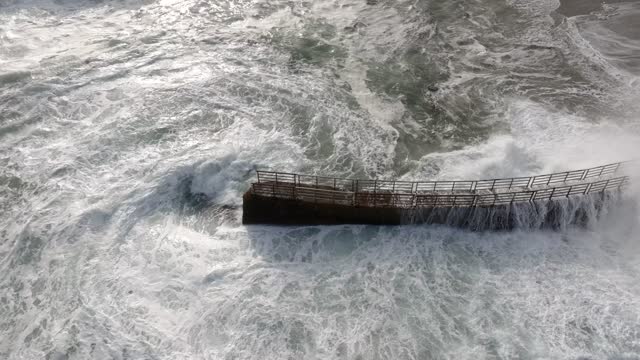 Aerial view of the cliffs, the surf and the ocean at La Jolla Cove.