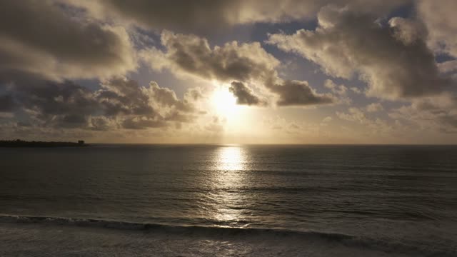 Low aerial view of the beach, the surf and the ocean at Black’s Beach.