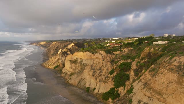 Aerial view of the cliffs, the surf and palm trees at Black’s Beach.