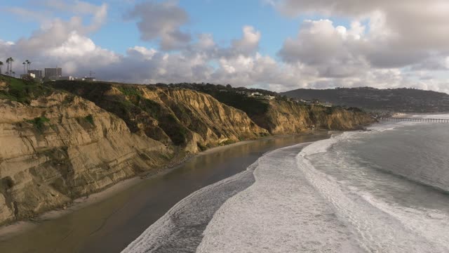 Aerial view of the cliffs, the surf and the pier at Black’s Beach.