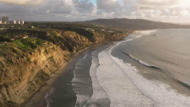 Aerial view of the cliffs, the surf and the pier at Black’s Beach.