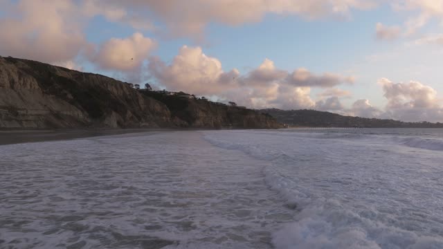 View from the water of the beach, the surf and the ocean at Black’s Beach.