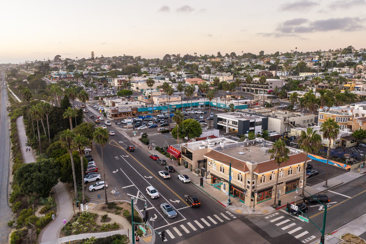 Aerial view of the downtown streets, palm trees and homes in Cardiff, with people walking.