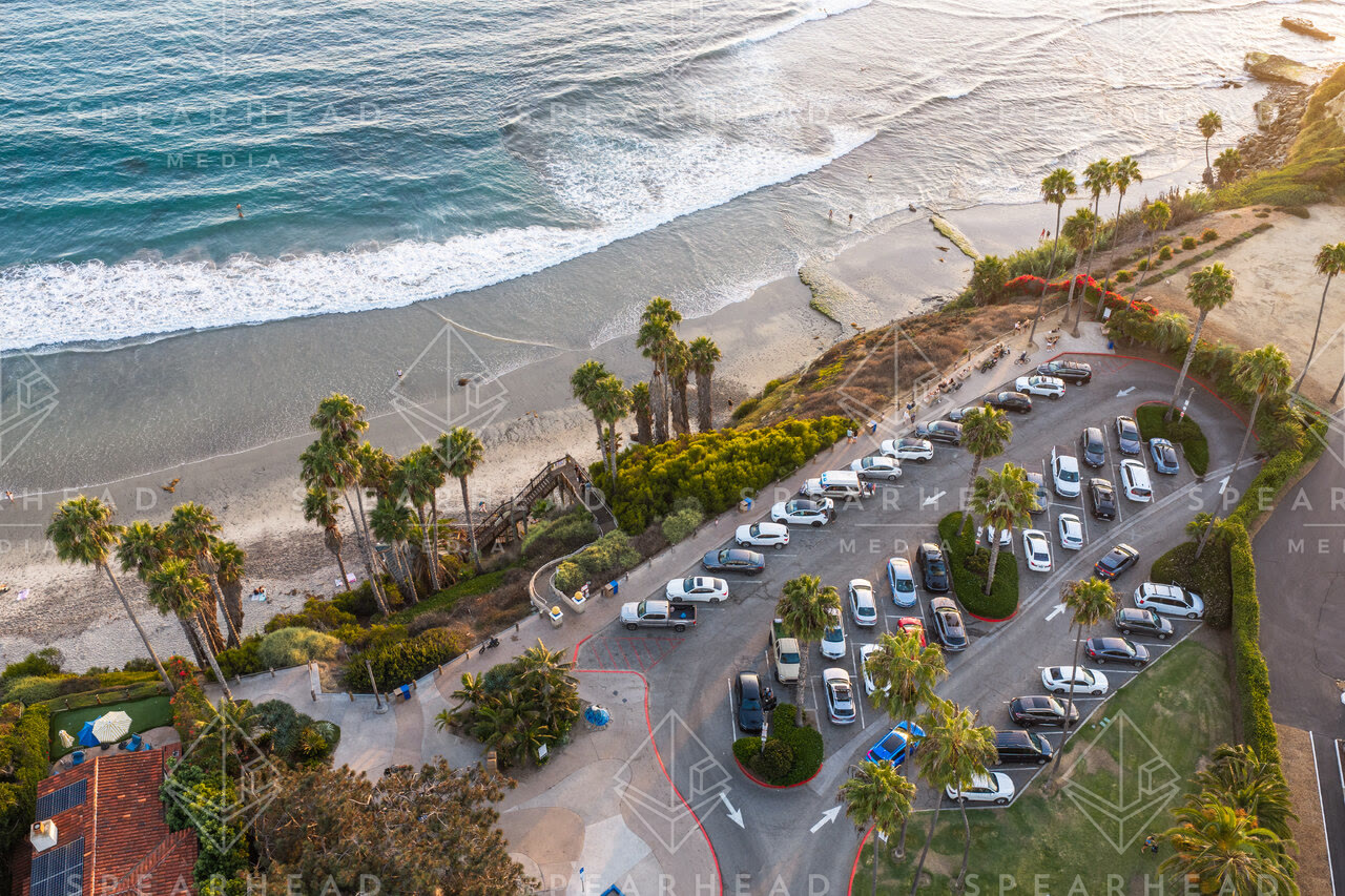 Aerial view of the beach, the surf and palm trees at Swamis, with people walking.