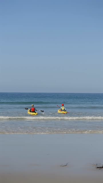 View from the water of the beach, the surf and the ocean at La Jolla Shores, with paddlers on the water.