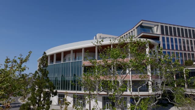 Aerial footage of the modern Research and Design District RADD building near the Embarcadero with city skyline and streets in Downtown San Diego | Drone Video