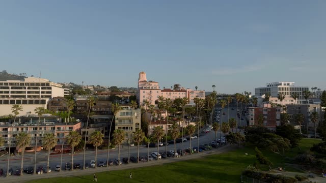 Aerial footage of the La Valencia Hotel and Scripps Park overlooking coastline and waves near La Jolla Cove in La Jolla | Drone Video