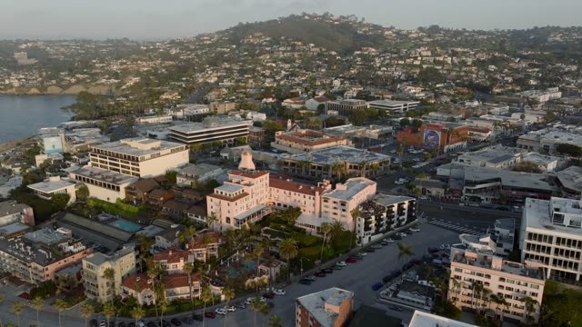 Aerial footage flying over the La Valencia Hotel, village streets and hillside homes above La Jolla Cove in La Jolla | Drone Video